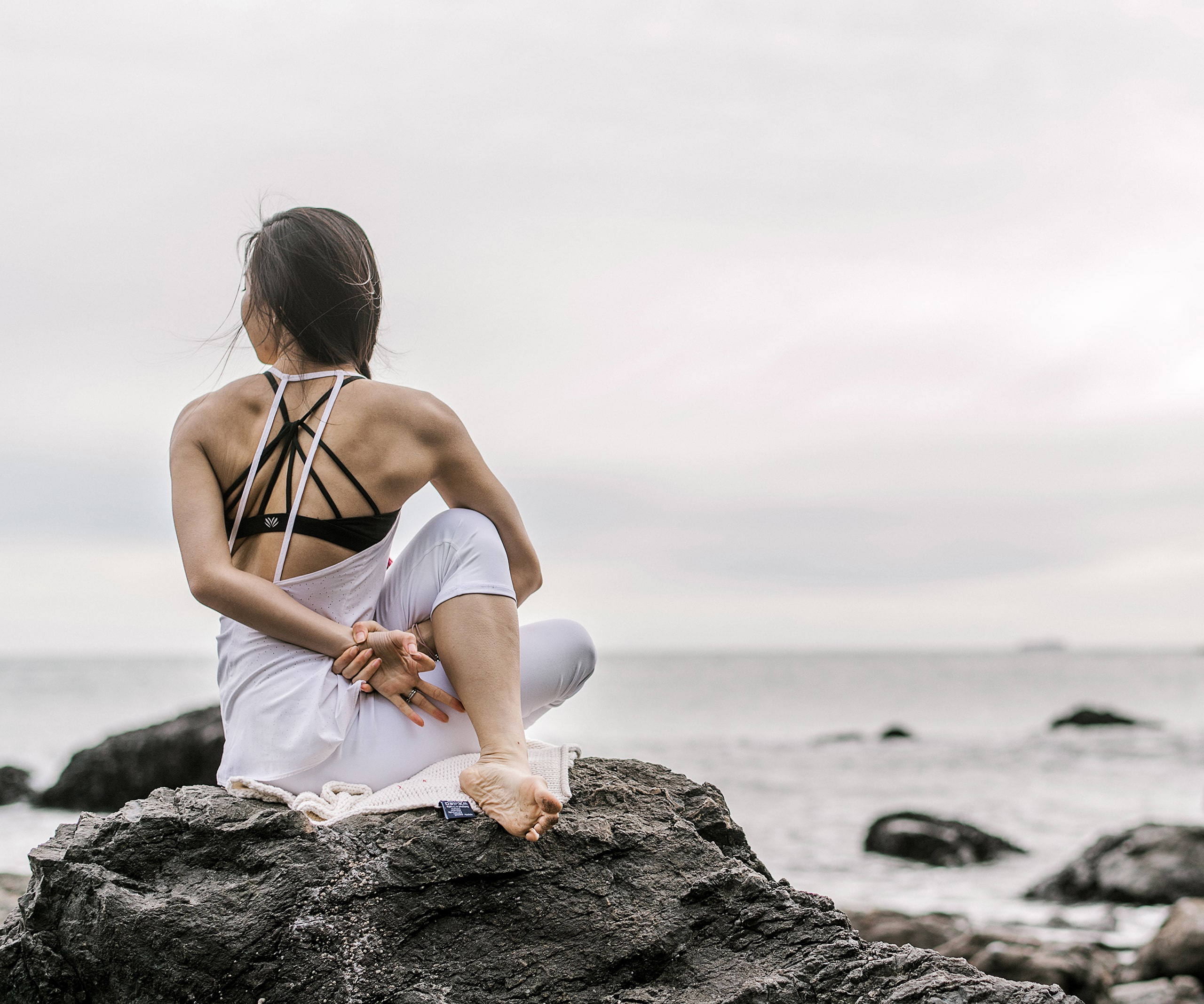 femme devant la mer en torsion assise